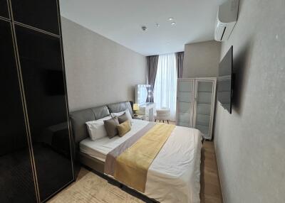 Modern bedroom with bed, wardrobe, TV, dressing table, and air conditioning