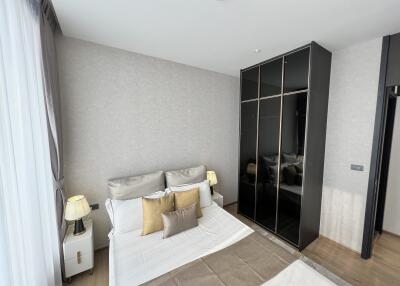 Modern bedroom with bed, side tables, and a wardrobe