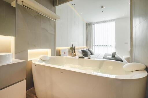 Modern bathroom with a free-standing bathtub and view into the bedroom