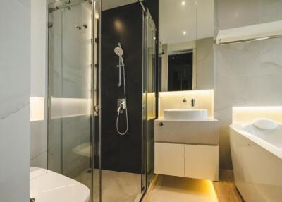 Modern bathroom with glass shower, vanity, and bathtub