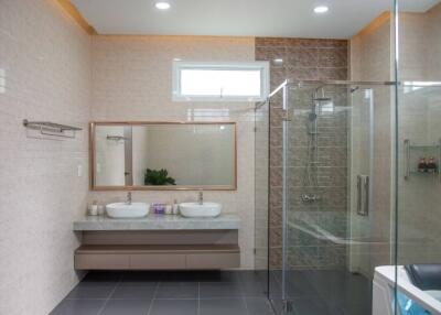Spacious modern bathroom with double sink vanity and glass shower enclosure