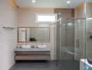 Spacious modern bathroom with double sink vanity and glass shower enclosure