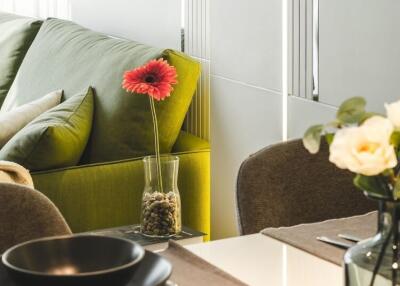 Modern living room with green sofa and decorative flowers