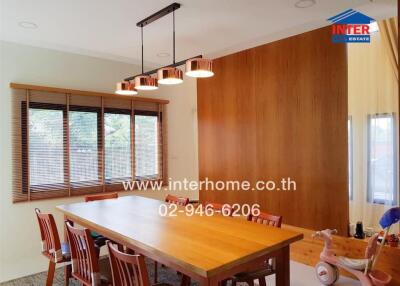 Dining room with wooden table, chairs, and a hanging light fixture