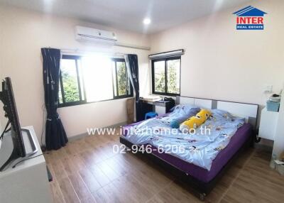 Spacious bedroom with large windows and air conditioning