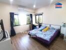 Spacious bedroom with large windows and air conditioning