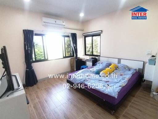 Spacious bedroom with large windows and air conditioning