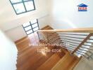 Well-lit wooden staircase with large windows