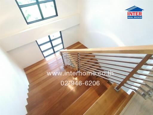 Well-lit wooden staircase with large windows