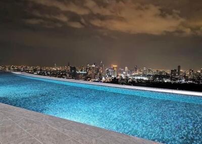 Rooftop infinity pool with city skyline view at night