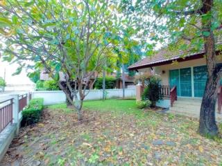 Front yard of a house with a lawn and surrounding trees