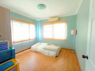 Bright bedroom with large windows and wooden flooring