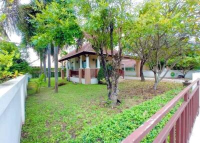 Front view of a house with a garden and trees