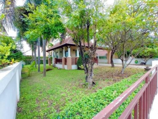 Front view of a house with a garden and trees