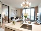 Modern open-plan living room with kitchen island, large window, and chandelier