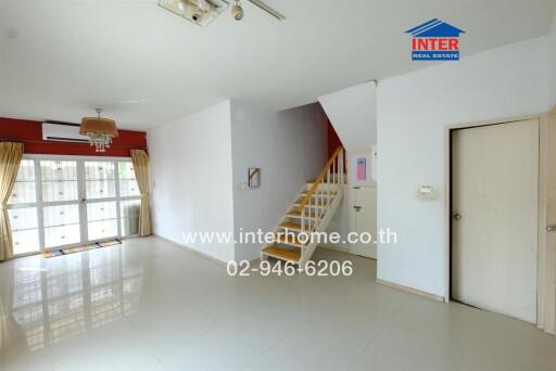 Bright and open main living area with staircase and large windows