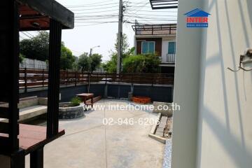 Outdoor view of a residential property with paved yard and seating area