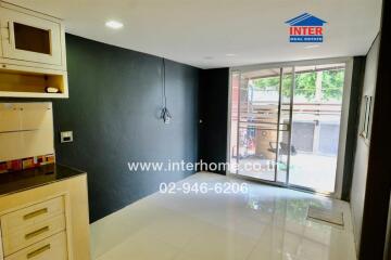 modern kitchen with black walls, white cabinets, and large sliding glass door