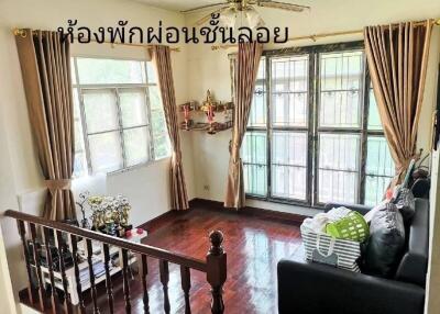 Living room with large windows, wooden floor, ceiling fan, and curtains