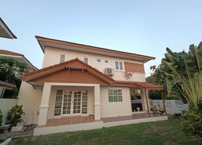 Front view of a two-story residential house with a garden