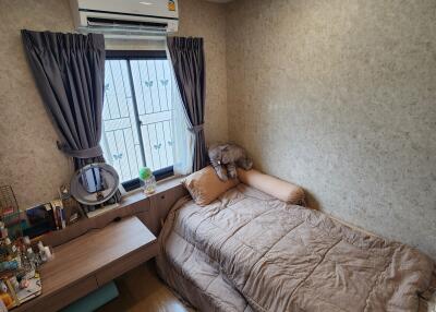 Small bedroom with a single bed, air conditioner, window with curtains, and a small desk.