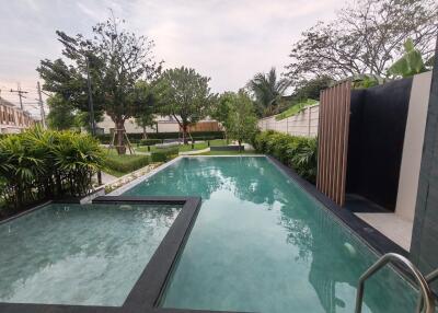 Modern residential outdoor pool area with lush greenery
