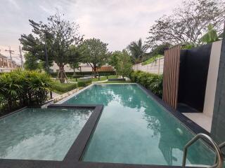 Modern residential outdoor pool area with lush greenery