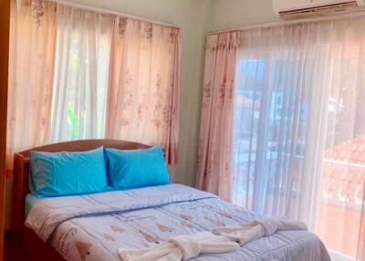 Cozy bedroom with double bed, blue pillows, and ample natural light