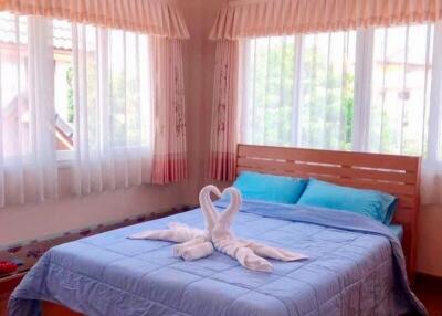 Bright bedroom with large windows, air conditioning, and neatly made bed
