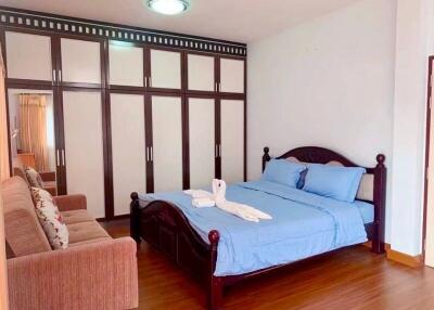 Spacious bedroom with a large wardrobe and a bed with blue linens