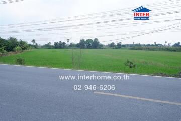 A view of a large vacant land area next to a paved road