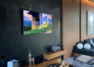 Modern living room with wooden decor, a wall-mounted TV, and contemporary furniture.