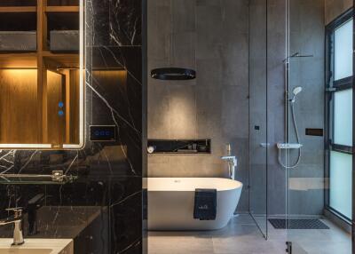 Modern bathroom with marble accents, freestanding bathtub, and glass-enclosed shower