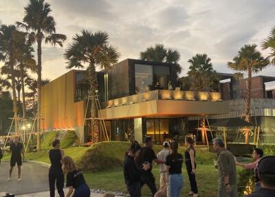 Modern building exterior with outdoor gathering area at sunset.