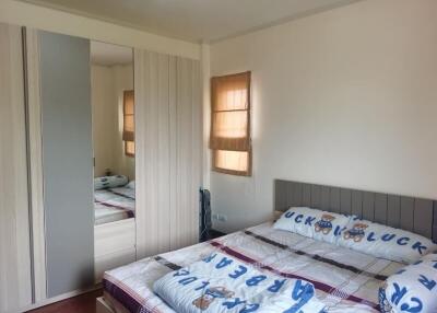 Cozy bedroom with a large bed, mirrored wardrobe, and window