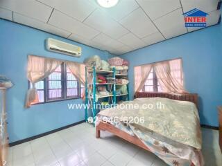 A cozy bedroom with blue walls, ample storage, and a window air conditioner.