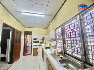 A bright kitchen with ample space, including countertops, cabinetry, and appliances.