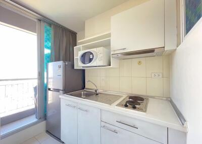 Compact kitchen with modern appliances and balcony view