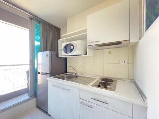 Compact kitchen with modern appliances and balcony view