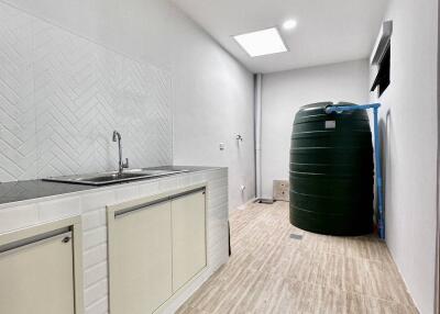 Spacious utility room with sink and water storage tank