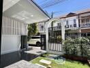 Covered patio leading to a garden area with a gate view of residential buildings