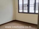 Empty bedroom with wooden floor and large window