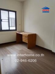 Small bedroom with a wooden desk and window