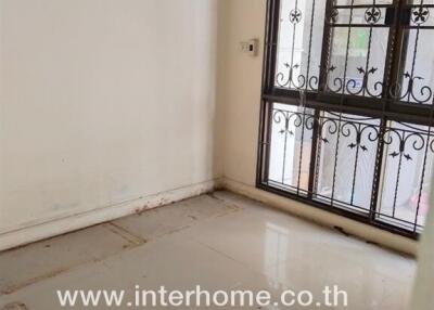 Empty room with tiled floor and window with metal bars