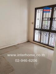 Empty room with tiled floor and window with metal bars