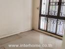 Empty room with tiled floor and window with metal bars