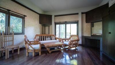 Living room with wooden furniture and large windows