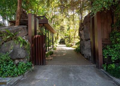 Entrance to a property surrounded by lush greenery and trees