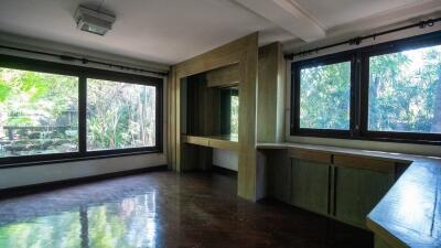 Spacious room with large windows and built-in cabinetry