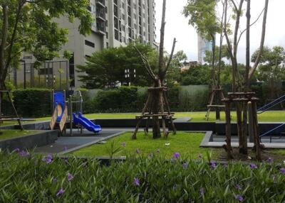 Residential outdoor playground area with slides and greenery